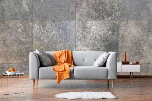 Orange blanket on grey scandinavian sofa, copy space on grey liv