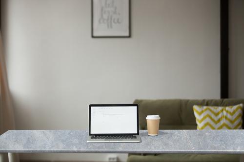 Working table with laptop, coffee and documents in home interior